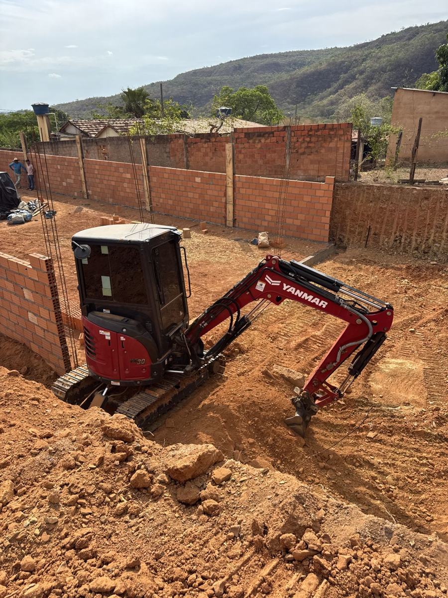 Mini escavadeira abrindo fundação em obra